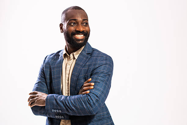 Portrait of happy and successful businessman. Black man in business suit is standing with arms crossed and smiling.